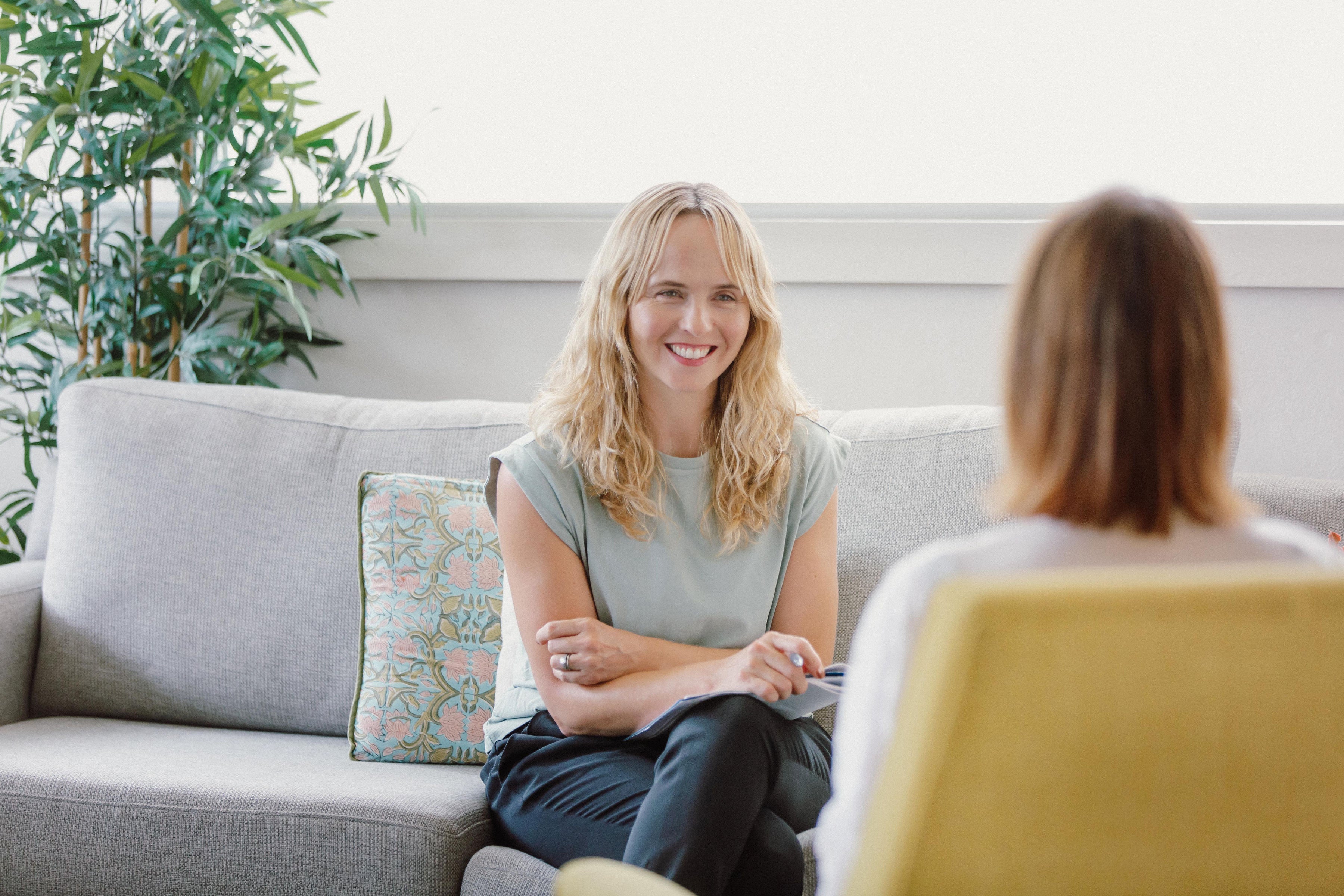 Penny Lucas sitting in a bright counselling room speaking with a client during a therapy session.